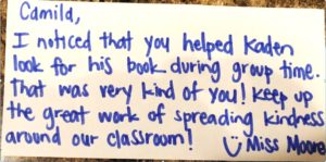 An image of a note from a teacher to a student explaining why they earned the character cash that is written on the back of that student's character cash